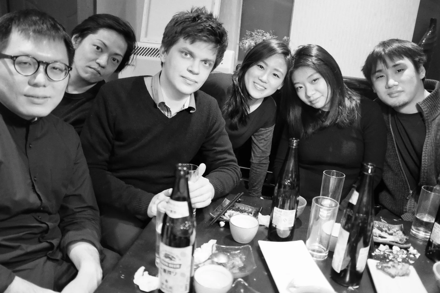 Tomasz with five MAD colleagues around a table of bottles after work