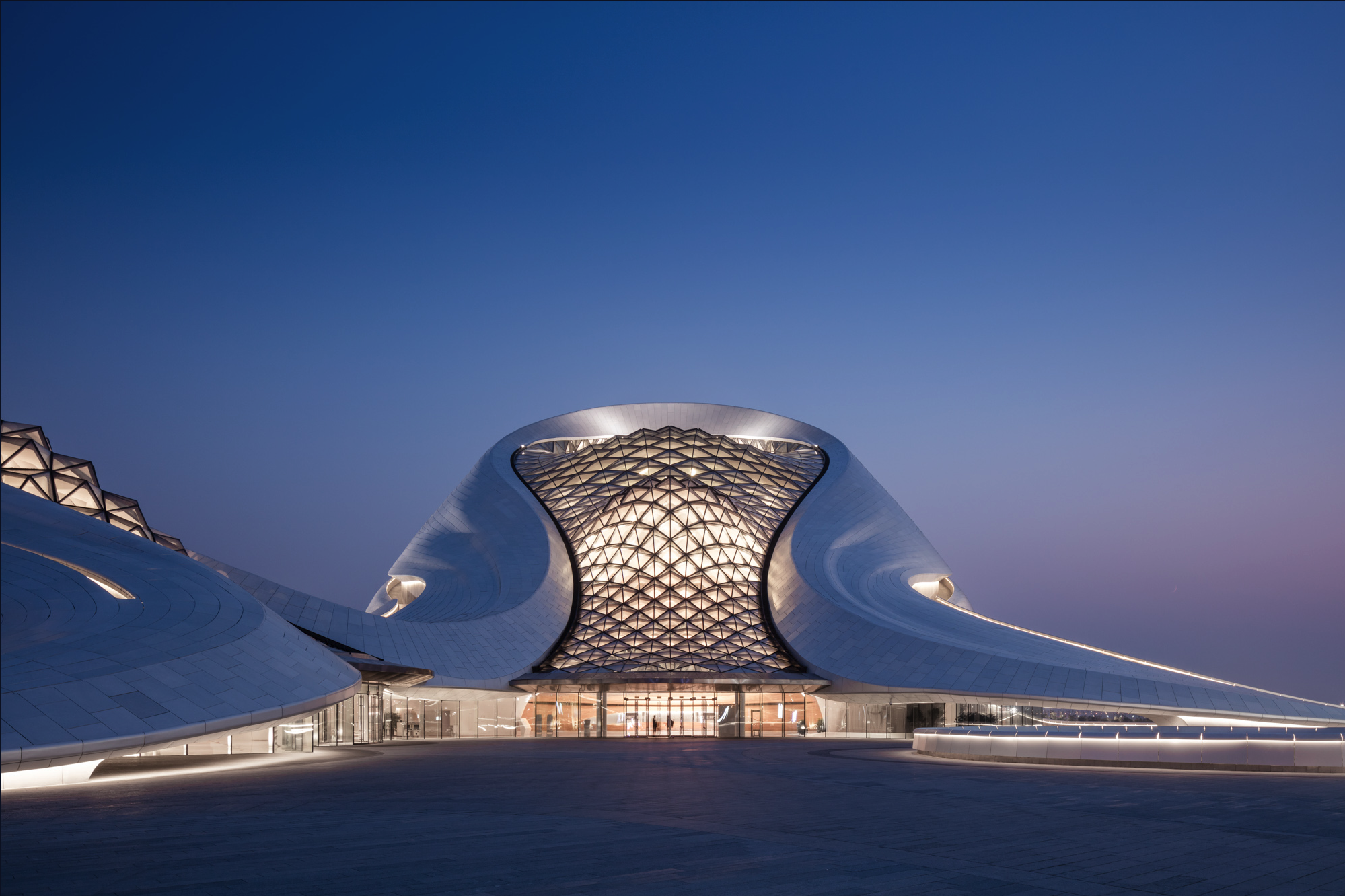 Harbin Opera House entrance at dusk under the lattice glass wall